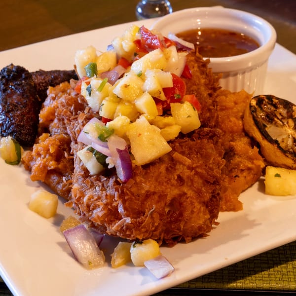 Crispy fried fish topped with pineapple salsa, served with plantains, mashed sweet potatoes, and sauce.