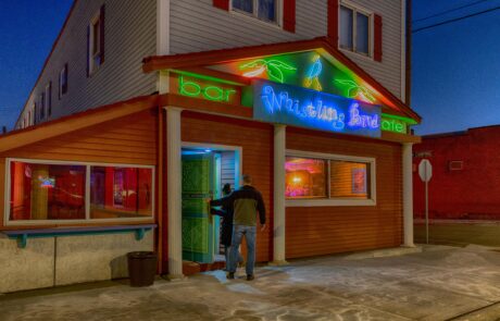 Couple walking into the Whistling Bird bar and cafe