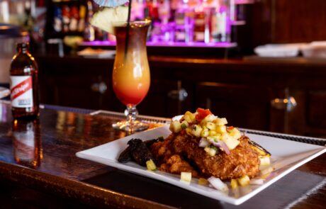 Blackened Mahi dish with pineapple salsa and a tropical drink