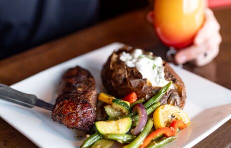 Steak and baked potato with tropical drink