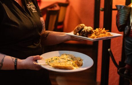 Server bringing out Caribbean style dishes to customers